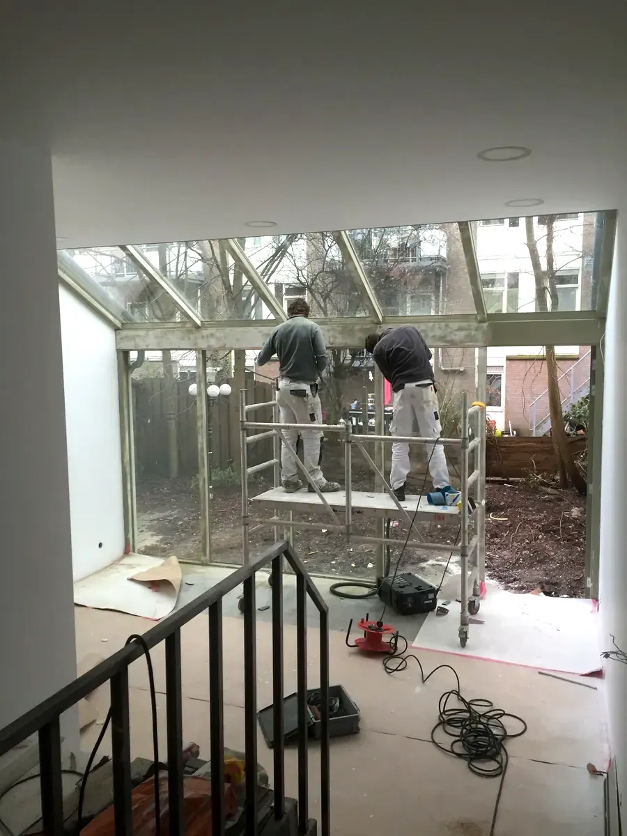 Gestripte woning wordt weer opgebouwd, vakmensen op steiger
